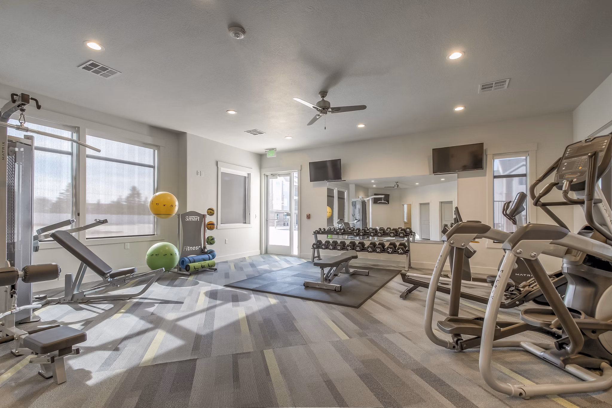 State-of-the-art fitness center featuring cardio machines and weights at One West Apartments