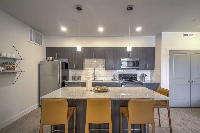 Kitchen featuring modern appliances and sleek countertops at One West Apartments