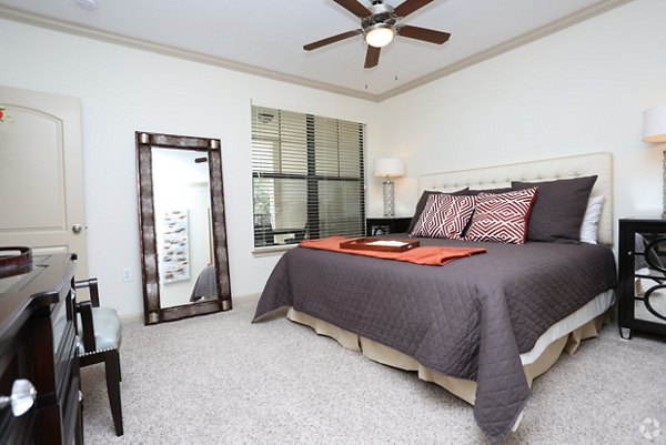 Cozy bedroom with modern furnishings at Braeswood Place Apartments: luxury living in a well-appointed interior space