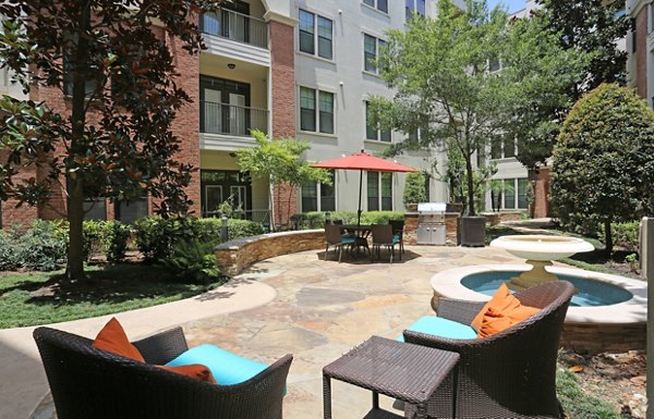 Courtyard with lush greenery and seating at Braeswood Place Apartments