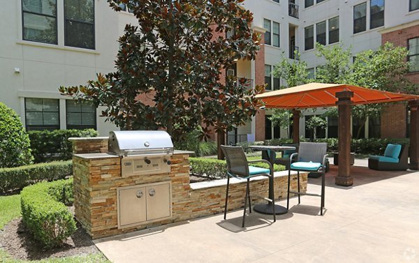 Outdoor grill area with modern setup at Braeswood Place Apartments, perfect for socializing and outdoor dining
