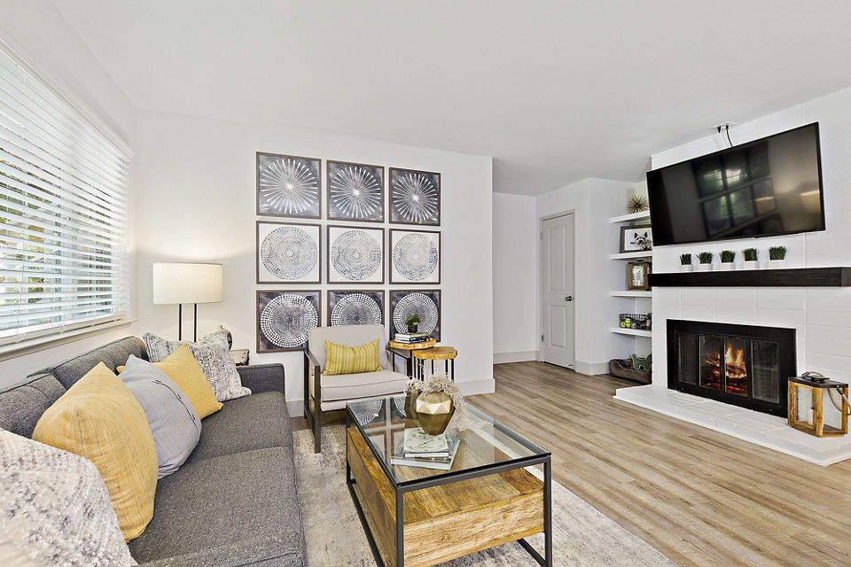 Modern living room with stylish sofa, armchair, fireplace, and wall art in luxury apartments