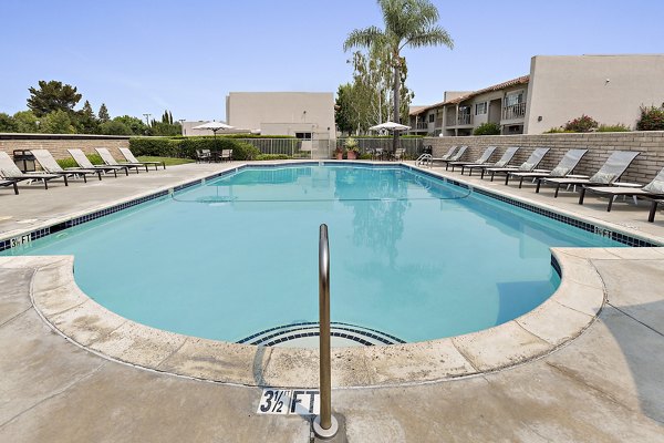 Relaxing swimming pool surrounded by red Adirondack chairs at luxury apartments