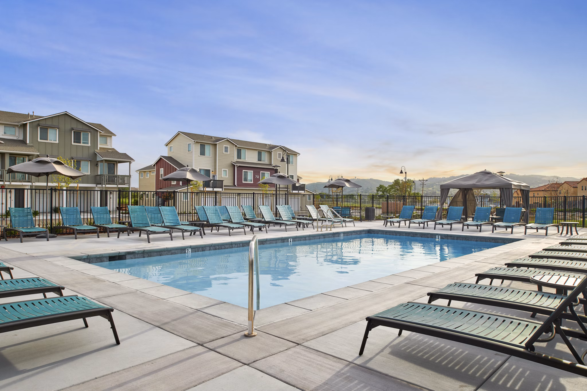 Outdoor pool with sun loungers at Blue Oak Apartments, offering luxury leisure in serene surroundings
