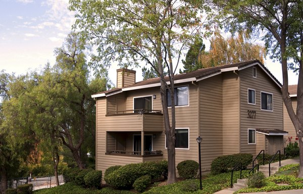 Lime Ridge Apartments: Two-story beige luxury apartments surrounded by lush greenery