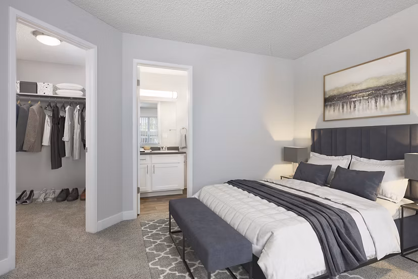 Cozy bedroom with a neutral palette in Autumn Springs Apartments, featuring plush bedding and ample natural light