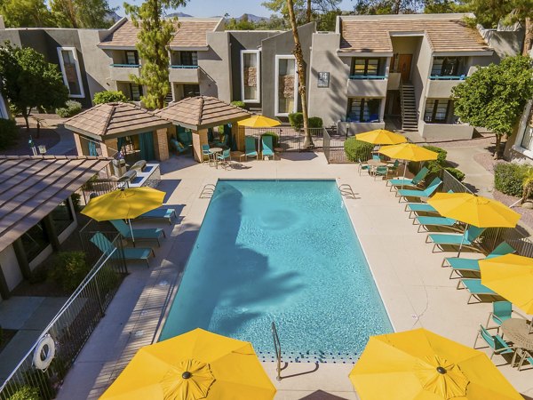 Outdoor pool with seating area at The Bella Apartments, offering a luxury retreat in a modern setting