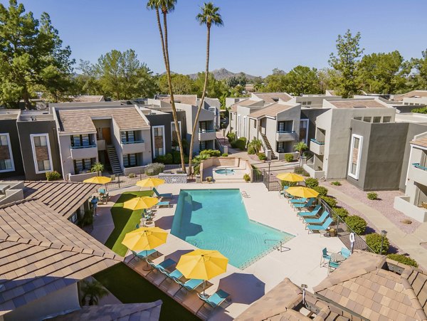 Resort-style pool with lounge chairs at The Bella Apartments