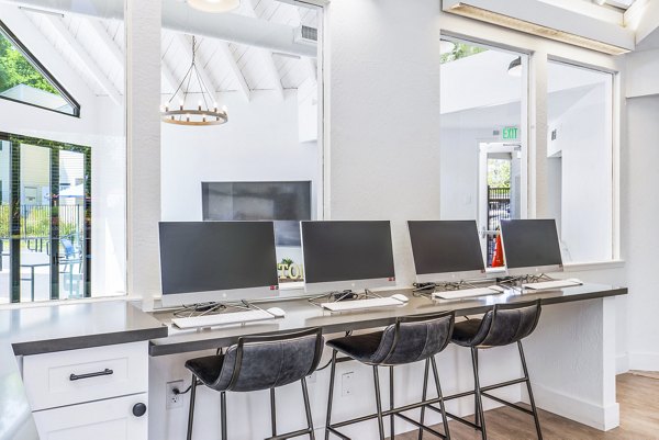 Clubhouse business center with modern workstations and sleek design in Kensington Apartments, ideal for remote work and meetings