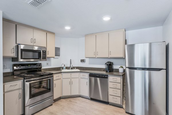 Kensington Apartments: Modern clubhouse kitchen with stainless steel appliances and communal seating