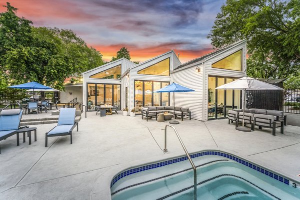 Outdoor pool at Kensington Apartments offering luxurious relaxation area with sun loungers and water features Ideal for leisure and recreation