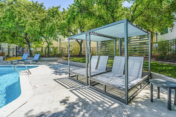Luxurious outdoor pool surrounded by lush landscaping at Kensington Apartments, offering a premier relaxation spot