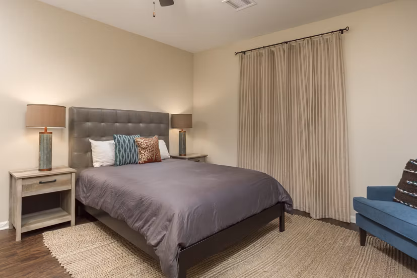 Elegant bedroom with cozy furnishings at Village at Aspen Place Apartments