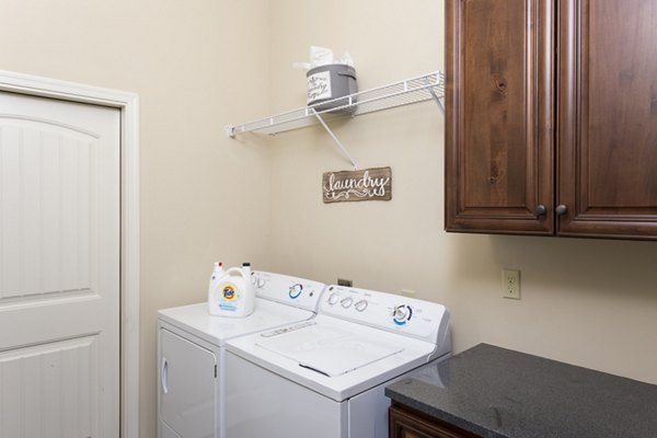 Laundry room with modern washers and dryers at Village at Aspen Place Apartments