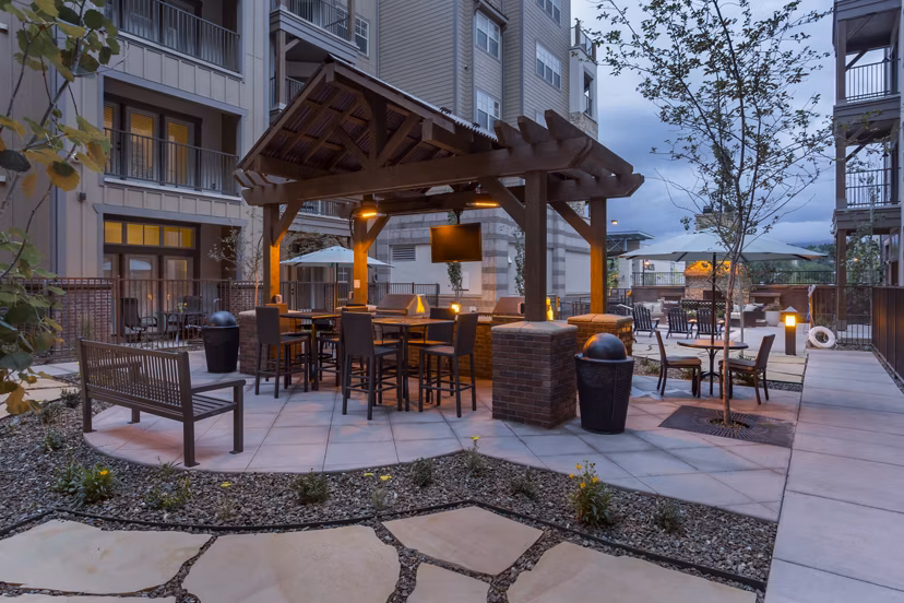 Outdoor grill area with seating at Village at Aspen Place Apartments, perfect for social gatherings and barbecues