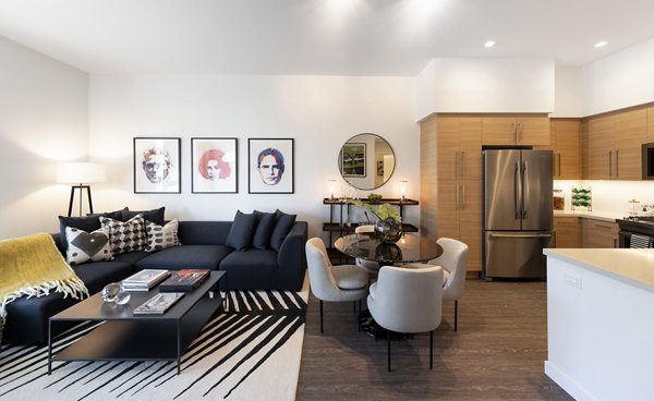 Elegant living room with modern furnishings and large windows at Talaria Apartments