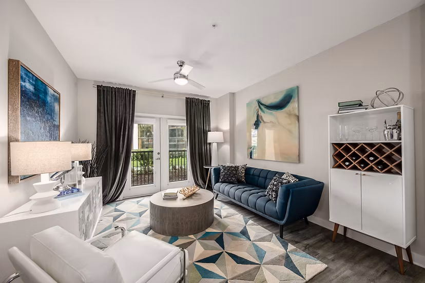 Modern living room with sleek furniture and large windows at Broadstone River House Apartments