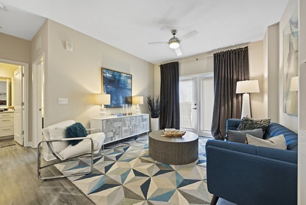 Modern living room with sleek furniture and large windows at Broadstone River House Apartments