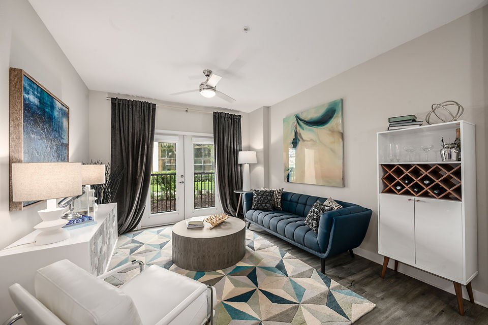 Modern living room with sleek furniture and large windows at Broadstone River House Apartments