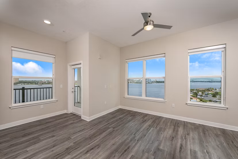 Contemporary living room with sleek furniture and large windows at Broadstone River House Apartments