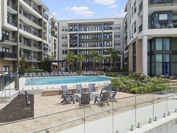 Pool area with sun loungers and greenery at Broadstone River House Apartments luxury community