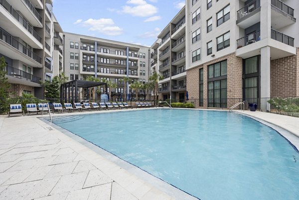 Resort-style pool at Broadstone River House Apartments with lounge seating and palm trees