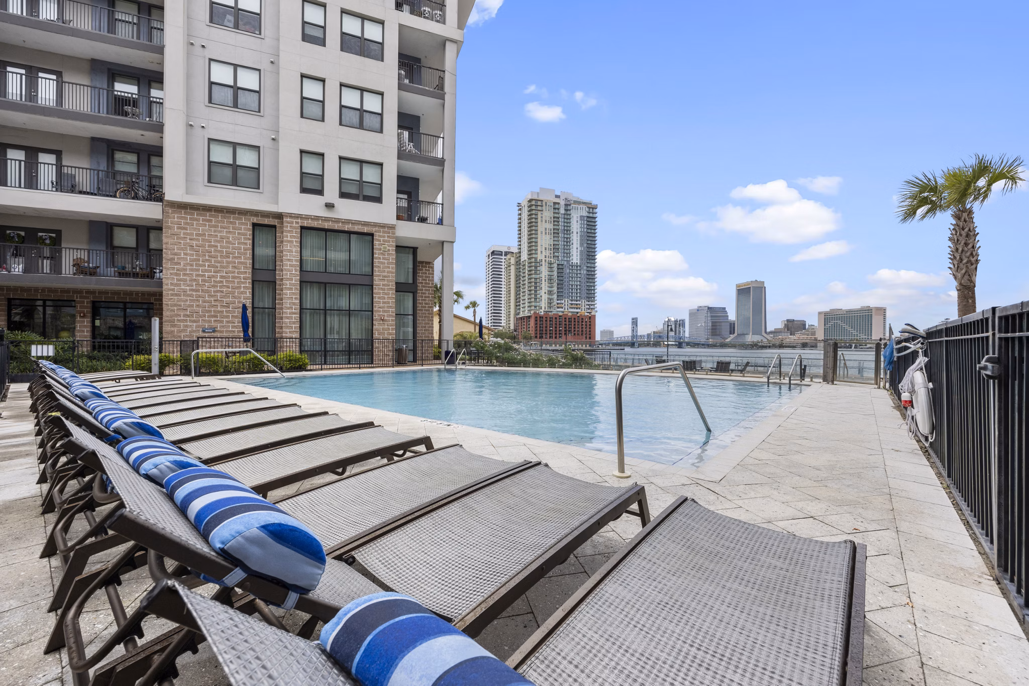 Inviting pool at Broadstone River House Apartments with lush landscaping and luxury seating options, perfect for relaxation