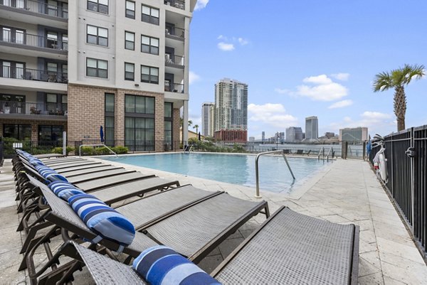 Inviting pool at Broadstone River House Apartments with lush landscaping and luxury seating options, perfect for relaxation