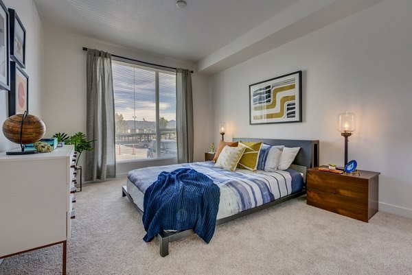Cozy bedroom featuring modern decor and large windows in Meridian Apartments