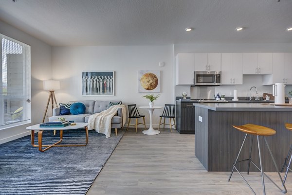 Spacious living room with modern decor and large windows in Meridian Apartments