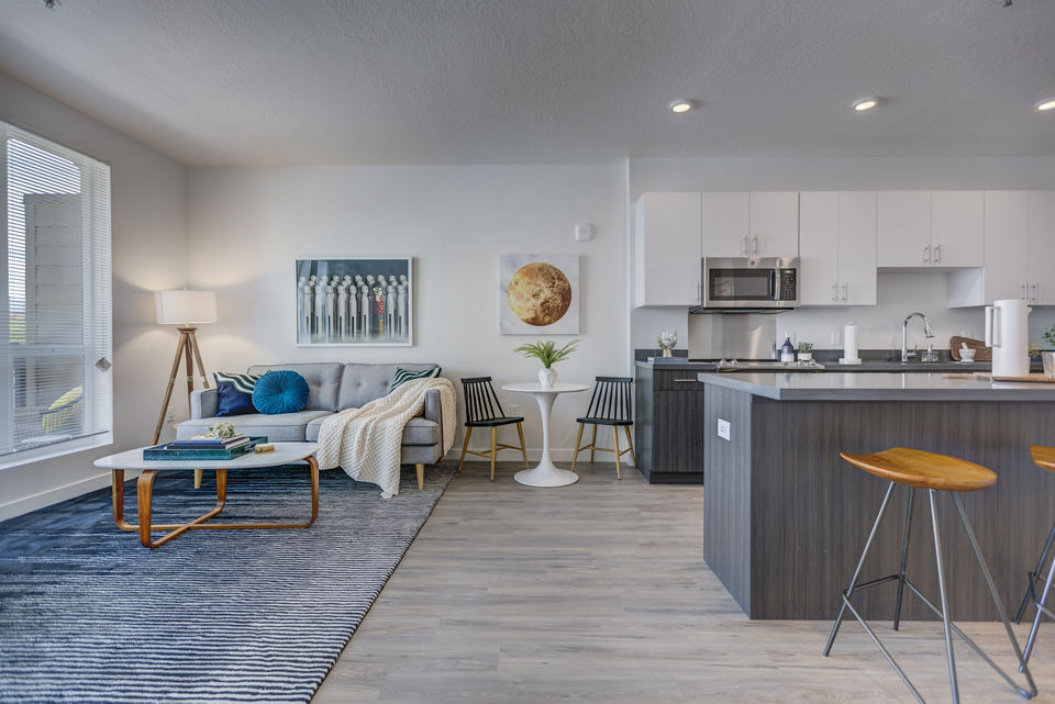 Spacious living room with modern decor and large windows in Meridian Apartments