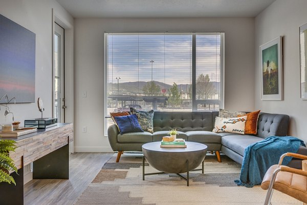 Modern living room with plush seating and large windows at Meridian Apartments, offering luxury living in the heart of the city