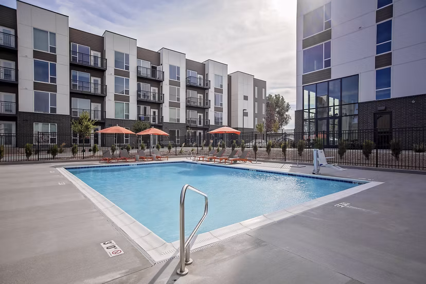 Modern outdoor pool at Meridian Apartments offering relaxing poolside seating and lush landscaping