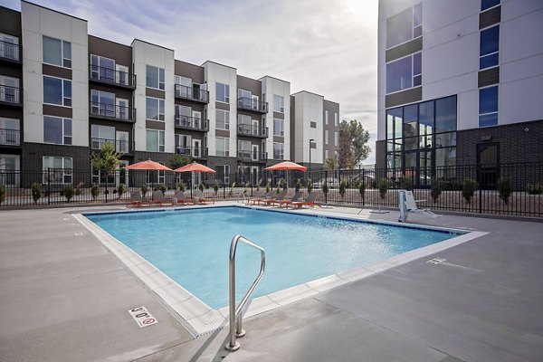 Modern outdoor pool at Meridian Apartments offering relaxing poolside seating and lush landscaping