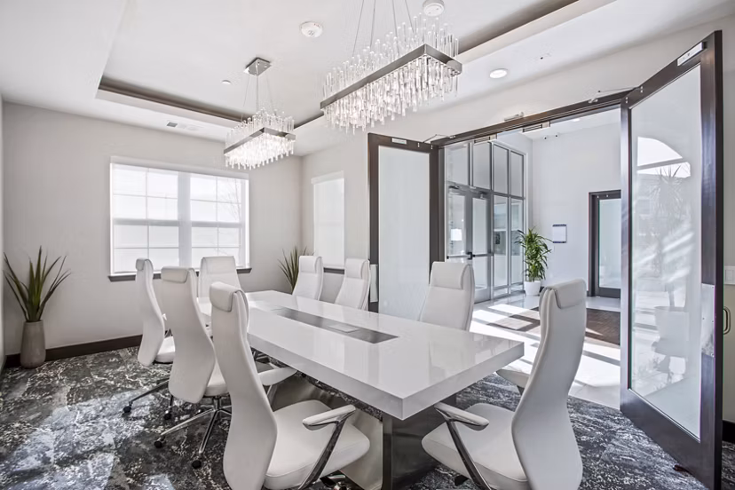 Clubhouse meeting facility with modern seating and presentation equipment at Inova Apartments