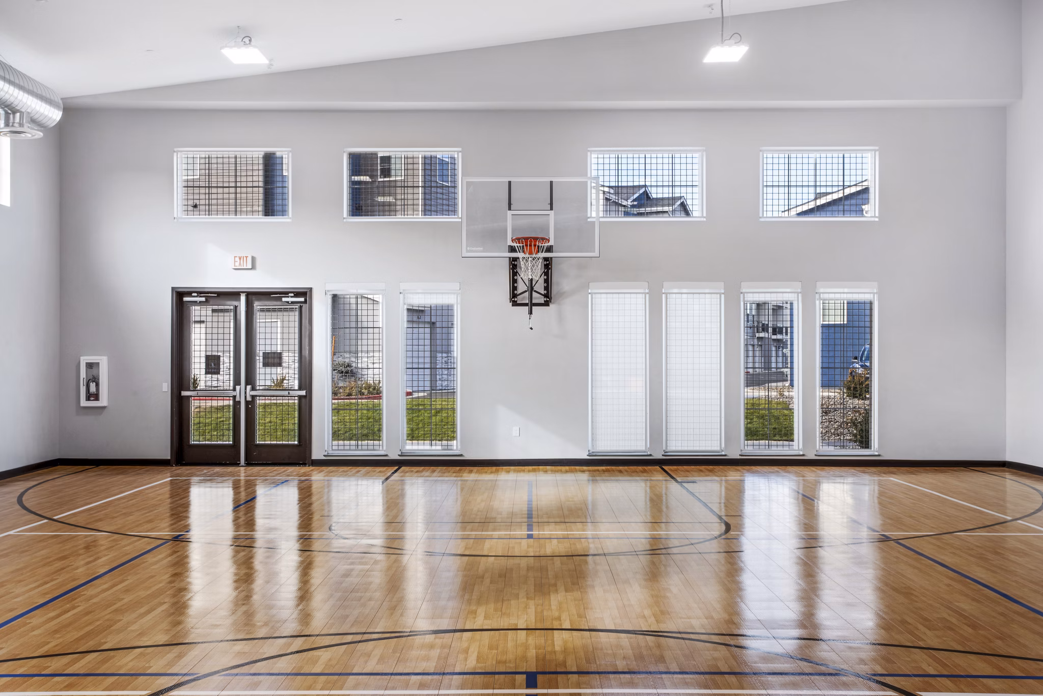 Basketball court with hardwood flooring at Inova Apartments, a luxury Greystar living community offering exclusive sports facilities