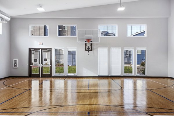 Basketball court with hardwood flooring at Inova Apartments, a luxury Greystar living community offering exclusive sports facilities