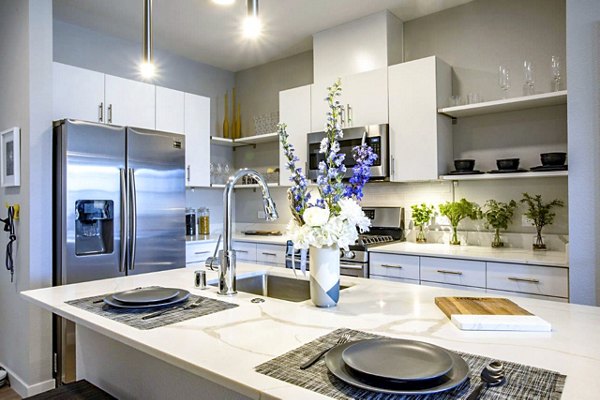 Modern kitchen with stainless steel appliances and quartz countertops at Inova Apartments