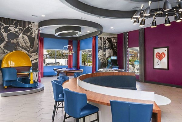 Modern clubhouse with seating and TV at Reverb at Spring Valley Apartments