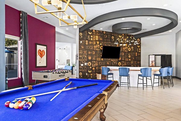 Clubhouse game room featuring billiards and lounge seating at Reverb at Spring Valley Apartments, a Greystar luxury apartment community