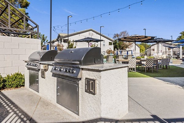 Outdoor grill area with modern seating for social gatherings at Reverb at Spring Valley luxury apartments