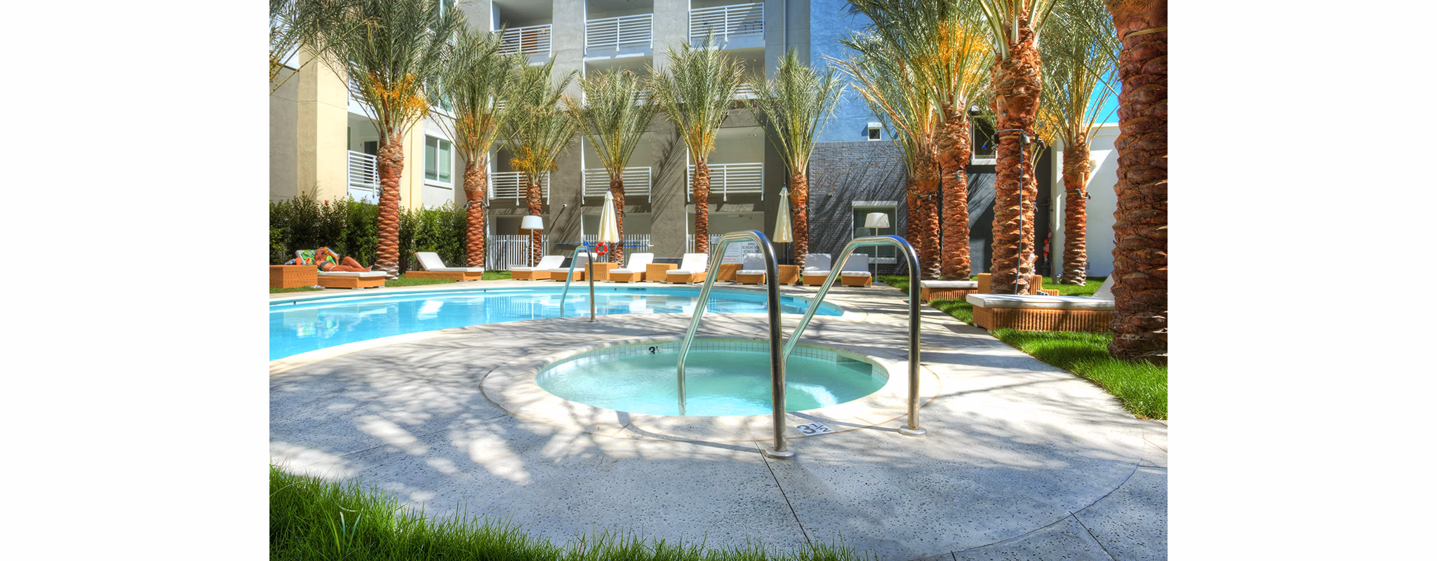 Luxurious pool area with sun loungers at Eton at Warner Center Apartments, offering a relaxing retreat for residents