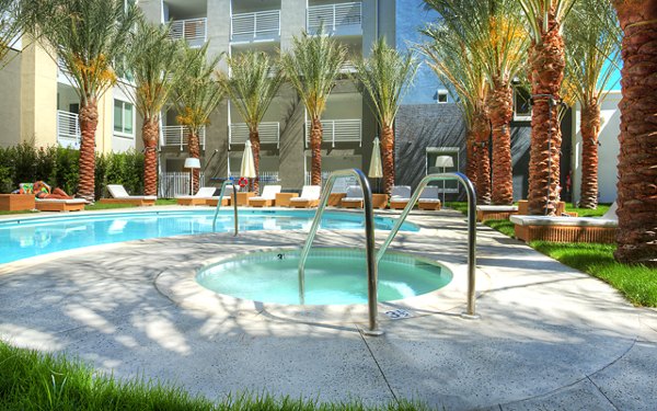 Luxurious pool area with sun loungers at Eton at Warner Center Apartments, offering a relaxing retreat for residents