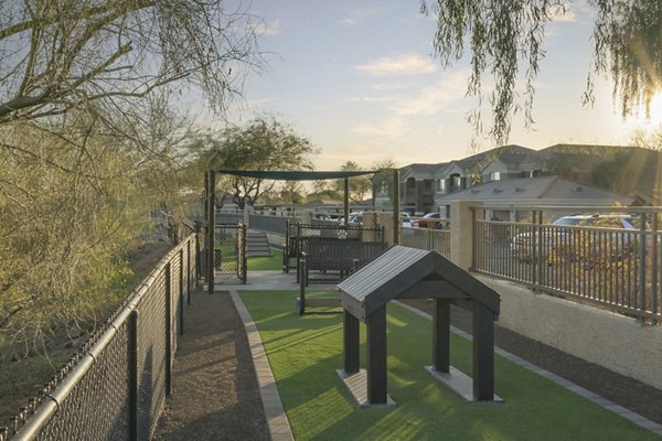 Well-maintained dog park surrounded by lush greenery at Adobe Ridge Apartments, ideal for pet owners seeking luxury living
