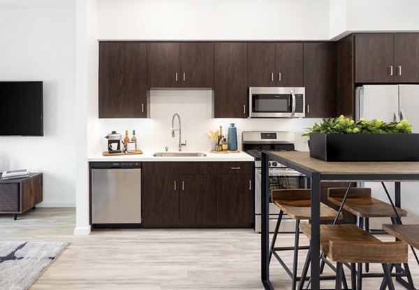 Modern kitchen with stainless steel appliances in 7403 Apartments, a luxury living option by Greystar