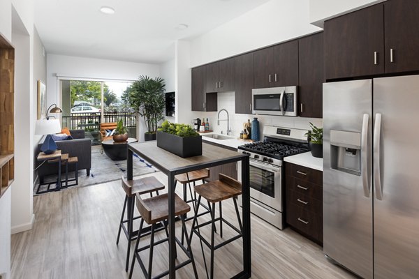 Modern kitchen with granite countertops and stainless steel appliances at 7403 Apartments