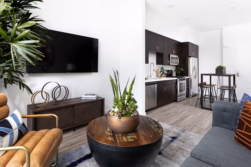 Bright living room with modern furniture and large windows at 7403 Apartments