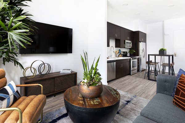 Bright living room with modern furniture and large windows at 7403 Apartments