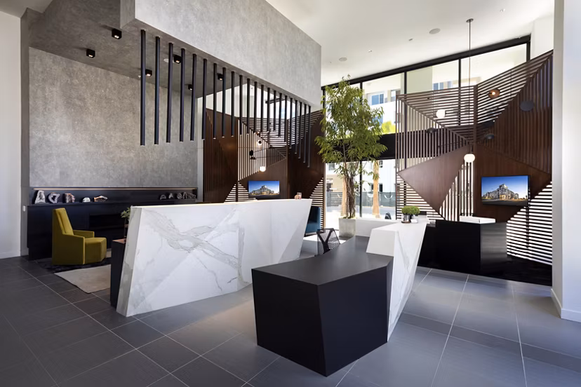 Modern office lobby with geometric decor and marble reception desk at Jefferson Edge Apartments