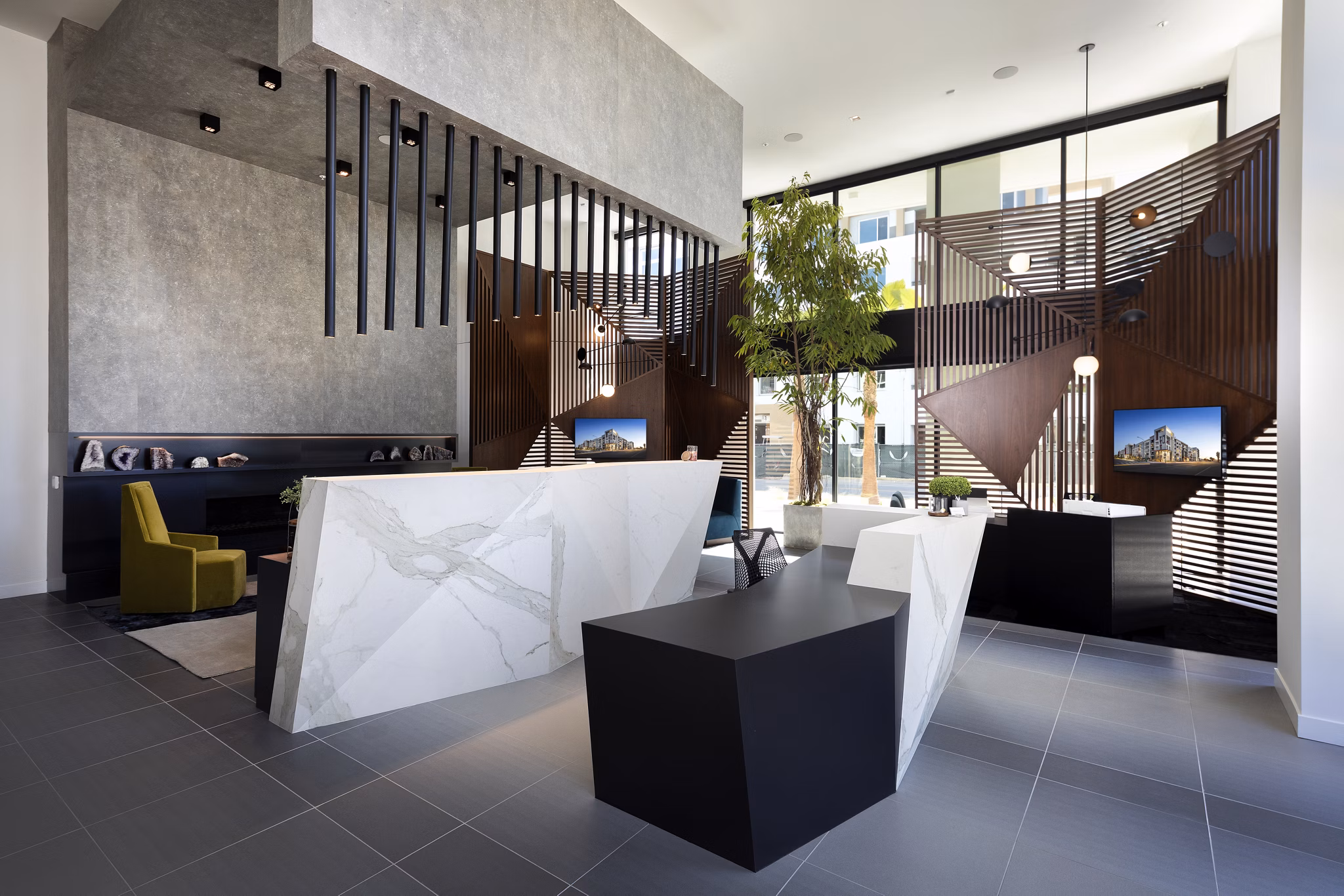 Modern office lobby with geometric decor and marble reception desk at Jefferson Edge Apartments
